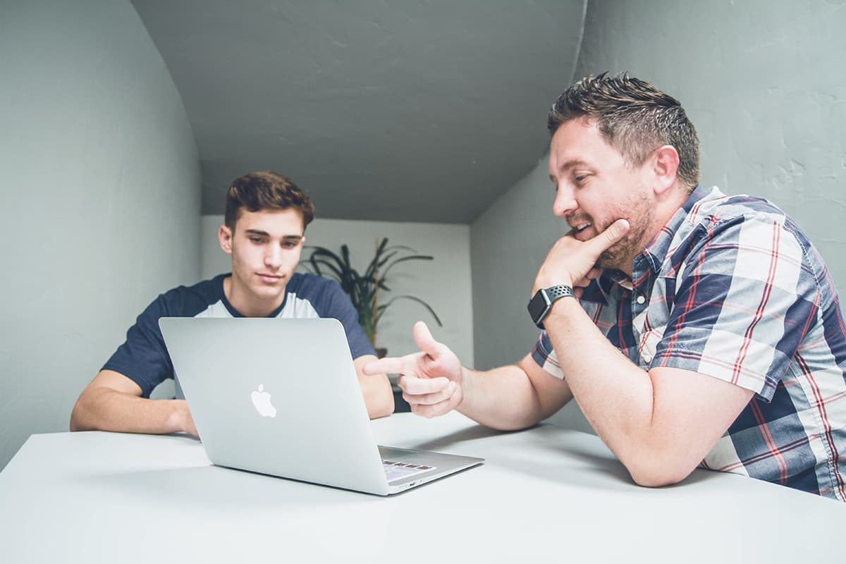 Two men looking at laptop screen.